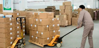 宜春服裝廠倉庫工人使用手動(dòng)叉車裝卸貨物